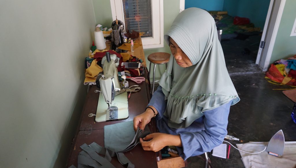 Indonesian woman handmaking masks from fabric