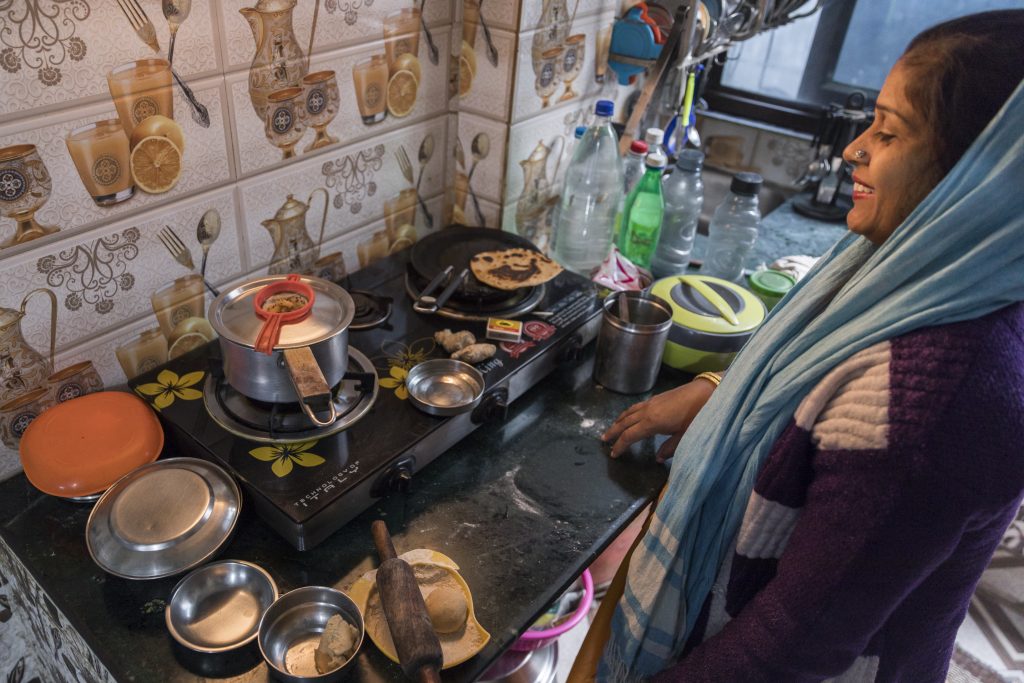 Indian mother woman Lata cooking with gas in the kitchen