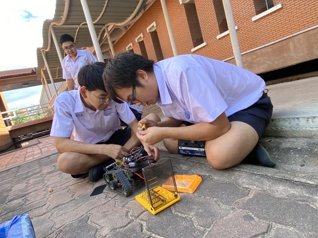 Two Thai students building a robot during the STEM camp competition